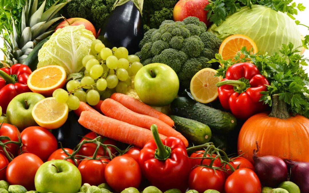 Photo of fresh produce including tomatoes, carrots, bell peppers, pumpkin, broccoli, grapes, cucumber, grapes, eggplant and apples.